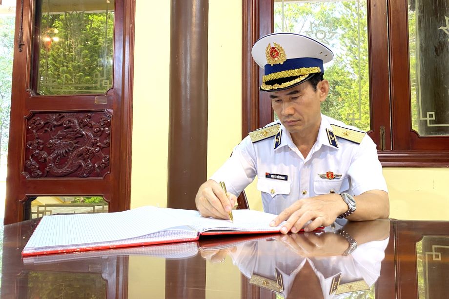 3. Chuẩn Đô đốc Nguyễn Hữu Thoan ghi sổ lưu niệm.jpg